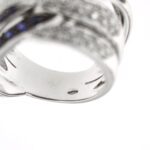 zoom dettaglio incisione interno punzone 750 oro su anello a fascia incrociata in oro bianco con diamanti e zaffiri