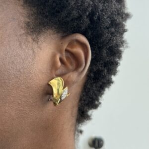 Foto gioiello indossata: orecchini a forma di uccellino in oro giallo con diamanti brand Damiani