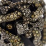 zoom dettaglio di pietre preziose su anello oro bianco brunito ricoperto di onice