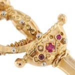 dettaglio zoom sui diamanti e rubini di spilla oro a forma di spada vintage