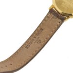 dettaglio incisione brand baume e mercier su cinturino marrone di orologio da donna in oro