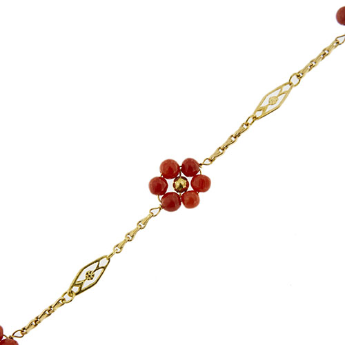 dettaglio zoom di fiore con corallo rosso su bracciale oro giallo