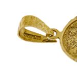 dettaglio zoom di gancio e incisione interna su ciondolo oro giallo con volto di gesù
