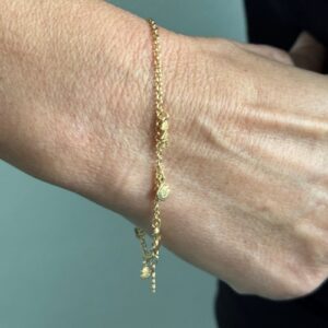 Foto gioiello indossata: bracciale in oro giallo con charms