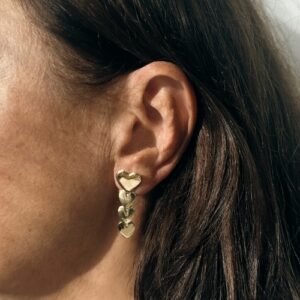 Foto gioiello indossata: orecchini pendenti in oro giallo con cuori