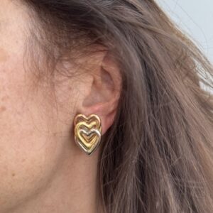 Foto gioiello indossata: orecchini a lobo a forma di cuori in oro