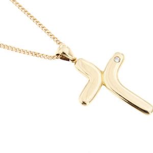 dettaglio ciondolo croce su collana oro giallo con diamante