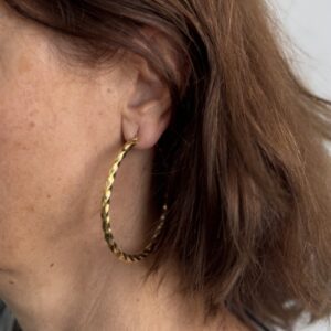 Foto gioiello indossata: orecchini a cerchio in oro giallo