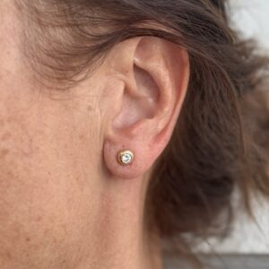 Foto gioiello indossata: orecchini punto luce cipollino in oro giallo con diamante